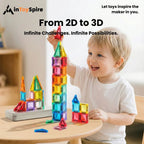 Young boy happily building colorful 3D tower with translucent magnetic toy blocks on wooden table