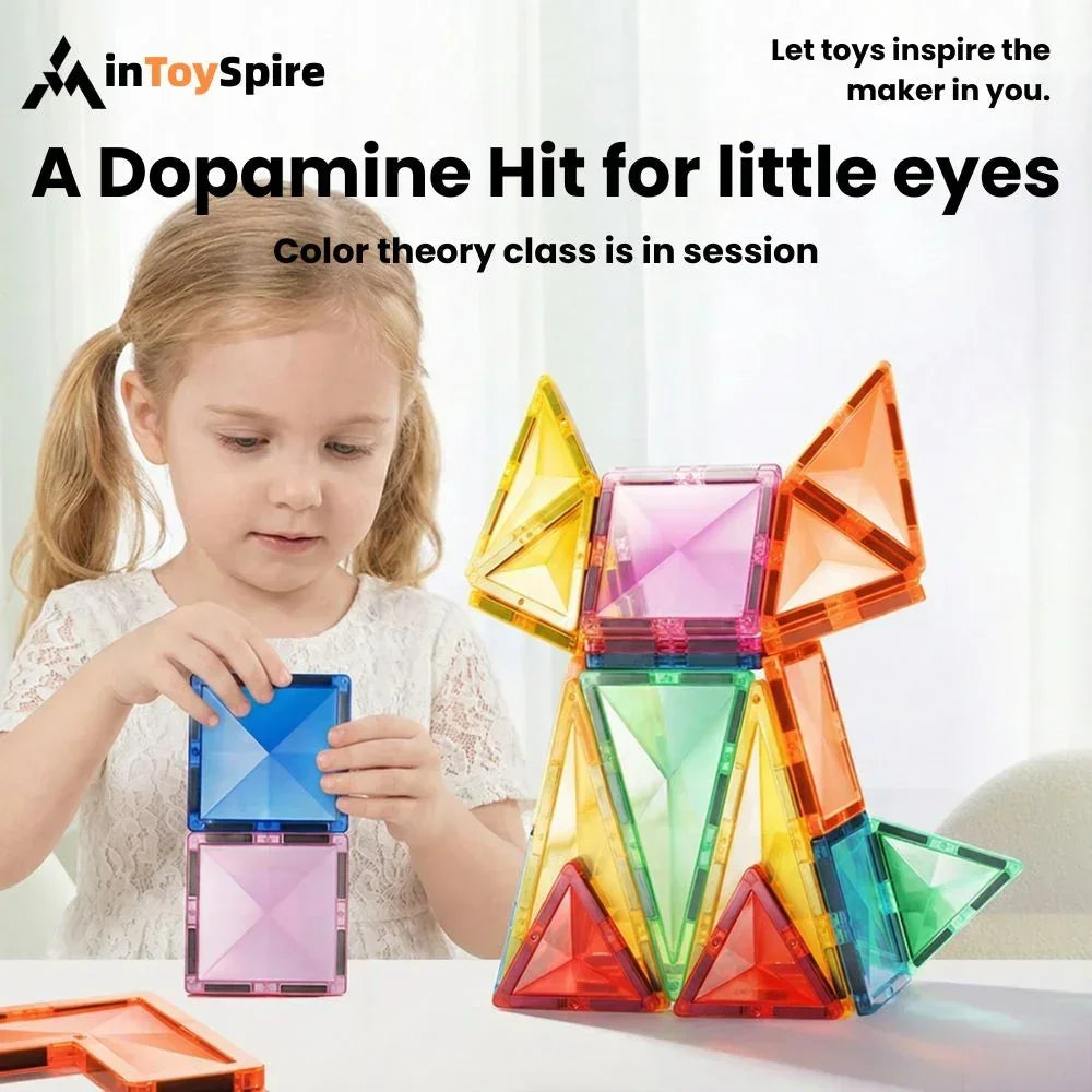 Young girl playing with colorful stained glass magnetic tiles, building geometric shapes